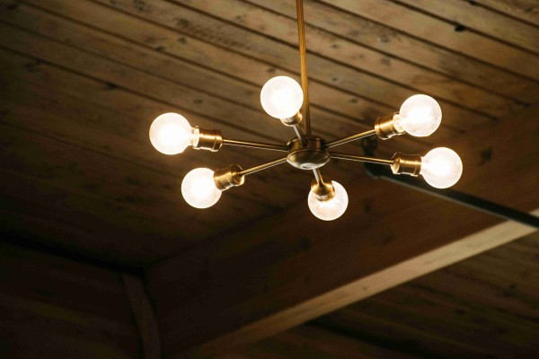 Modern chandelier with six light bulbs, stylish wooden ceiling decor