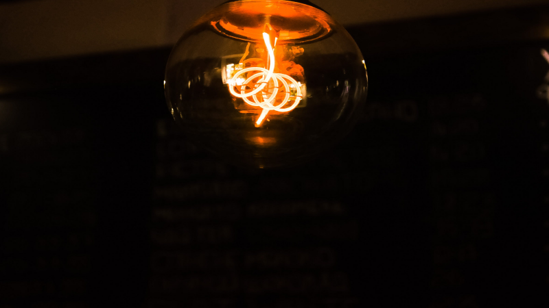 Close-up of a glowing LED bulb with intricate filament design in a dimly lit ambiance.