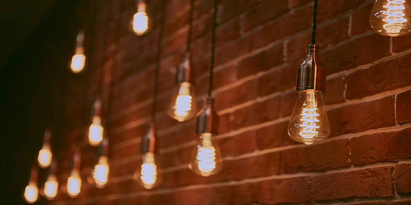 hanging Edison bulbs against a brick wall, warm decorative lighting