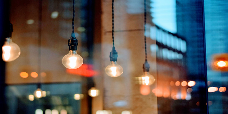 Hanging filament bulbs reflecting through a glass window