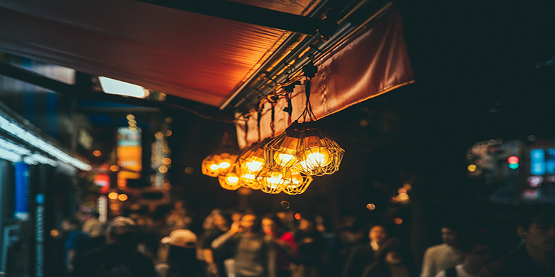 Warm decorative lights hanging above a vibrant night market