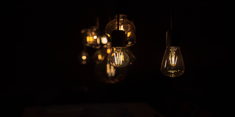 Cluster of LED filament bulbs in a dark room, warm cozy atmosphere