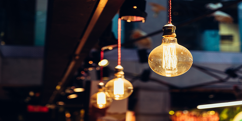 LED filament bulbs hanging in a modern urban cafe, soft ambient glow