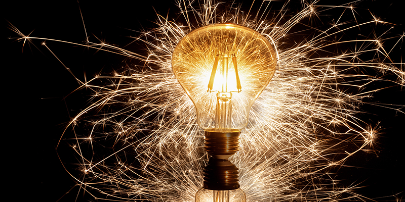 LED filament bulb glowing with sparkling fireworks, creative lighting concept