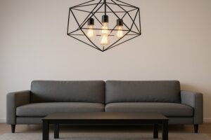 Image of a modern, minimalist living room where a geometric pendant light fixture showcases several clear classic-shaped LED Edison bulbs.